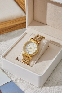 Dettaglio di un orologio al quarzo dorato con strass e numeri romani in una confezione