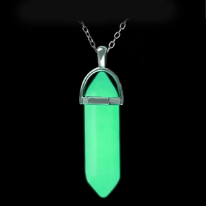 Detailed close-up of a glowing green hexagonal crystal pendant on a silver chain