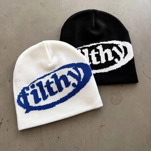 Flat lay of knit beanies in white and black featuring filthy graphic print detail