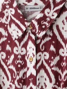 Close-up of retro geometric print fabric and neckline details on short sleeve shirt