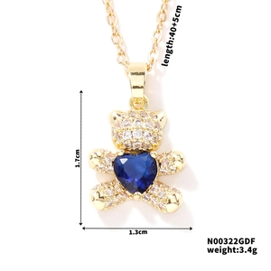 Macro view of gold teddy bear pendant with blue heart zircon and size specifications