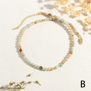 Macro shot of 2-3mm colorful natural stone beads with golden clasp and extender chain