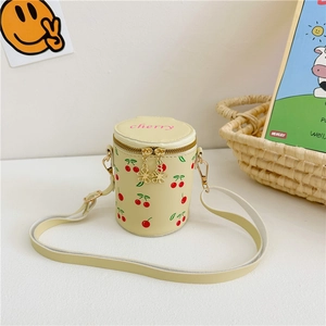 Détail du sac cylindre beige avec imprimé cerise et broderie cerise rose en haut
