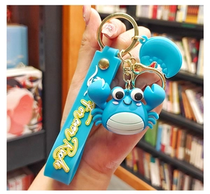 Blue cartoon crab keychain with Forever Rich silicone strap and gold metal hardware