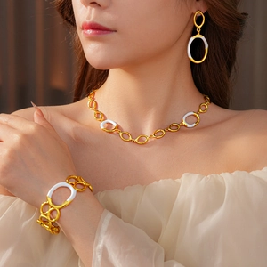 Detailed view of model wearing gold and white enamel oval link jewelry set with necklace