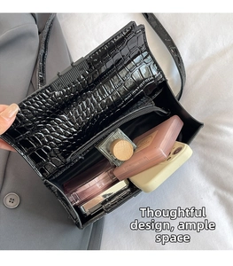 Macro view of black croc-embossed handbag interior with zippered pocket and ample space