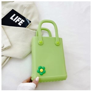 Detail der grünen EVA-Mini-Tasche mit gelbem Blumenanhänger und robuster Gummistruktur