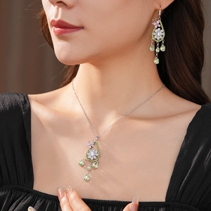 Dettaglio del set gioielli con farfalla in zircone e nappine indossato da modella