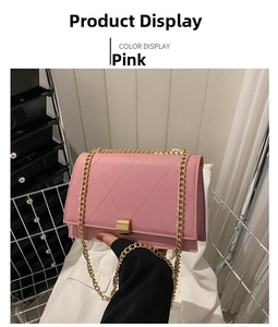 Detailed view of pink quilted handbag with gold chain strap and metal clasp closure