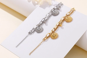 Detailed close-up of gold and silver sun pendant bracelets with asymmetric link chains
