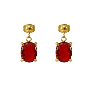 Macro detail of gold-plated oval red zircon earrings with classic 4-prong setting