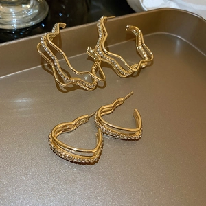 Chic triple-layered gold heart and star earrings with pavé crystals on metal tray