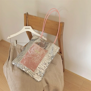 Detail of glitter silver sequin tote bag featuring pink velvet pocket and rope handle