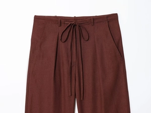 Detail of dark brown casual pants featuring drawstring waist and side slash pockets