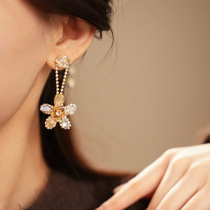 Close-up of elegant flower tassel earrings with white pearls and sparkling zircons