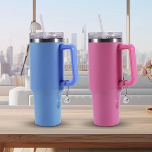Detail of blue and pink insulated tumblers with crystal ball charms on the handles
