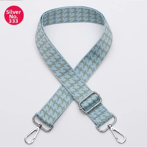 Macro detail of wide grey-blue houndstooth woven strap with silver metal hardware