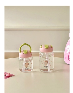 Close-up of portable glass water bottle with pink lid and cute cartoon sheep pattern