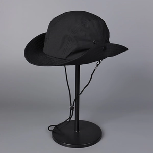 Detail of lightweight black sun hat featuring metal vents and adjustable snap buttons