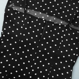 Close-up of back cutout detail on polka dot dress with adjustable straps and zipper