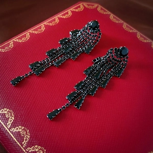 Détail de boucles d'oreilles gothiques à longs glands noirs avec cristaux brillants