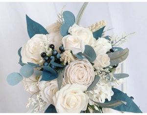 Detailed close-up of bridal bouquet with white roses, blue berries and eucalyptus leaves