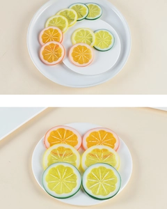 Macro shot of realistic PVC lemon slices in yellow, green and orange on ceramic plate