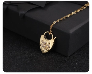 Macro detail of 18K gold plated heart lock pendant with snake and star zircon patterns