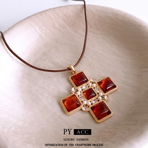 Vintage cross pendant necklace with reddish-brown stones and pearls on leather cord
