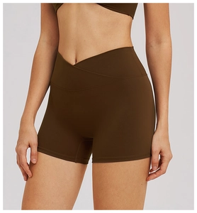 Detail of the high-rise V-waist design on dark brown yoga shorts with matte texture