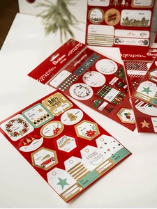 Close-up of festive Christmas gift tag stickers with holiday patterns and writing space