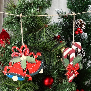 Wooden Christmas tree ornaments featuring red bell and candy cane on festive pine branch