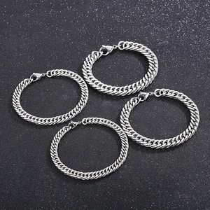 Set of four stainless steel curb chain bracelets with lobster clasp on black background