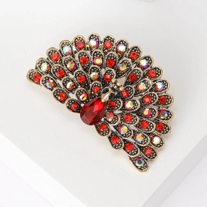 Detailed macro view of vintage peacock brooch featuring red and iridescent rhinestones