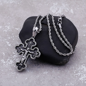 Retro stainless steel cross pendant with Jesus relief on a dark textured stone background