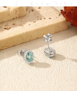 Detail of oval mint green moissanite earrings with halo diamonds on stone base