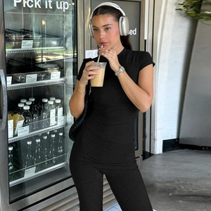 Vista street style di un set coordinato nero slim fit con crop top, pantaloni e cuffie