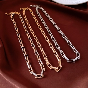 Detail of adjustable alloy chain necklaces in gold and silver on silk background