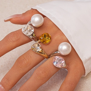 Close-up of elegant rings with pearls and colorful crystals on model's hand