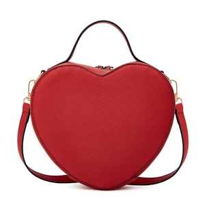 Detailed shot of red heart-shaped handbag with textured leather and gold hardware