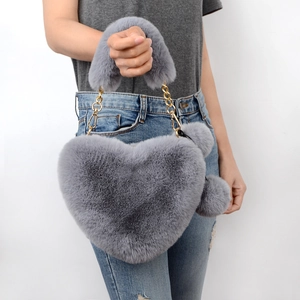 Borsa a mano grigia in ecopelliccia a cuore con pompon e dettagli a catena dorata