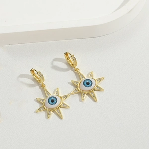 Detailed shot of golden evil eye and sunburst hoop earrings with sparkling zircon inlay