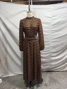 Close-up of elegant pleated brown polka dot dress featuring a high collar and metal waist buckle