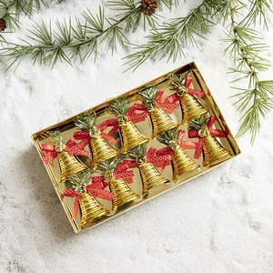 Set of 12 gold Christmas bell ornaments with red bows and green pine on snowy background