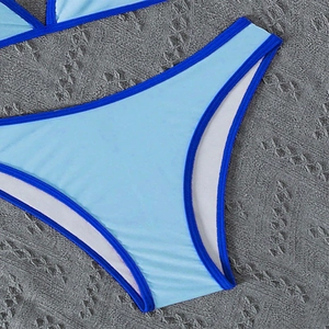 Detail of light blue bikini bottom with dark blue trim edges and high-elastic fabric