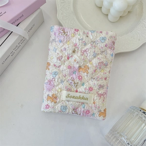 Quilted fabric passport holder with cute puppy floral patterns on a display tray