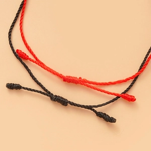 Dettaglio macro di braccialetti in corda intrecciata rossa e nera con nodi fatti a mano