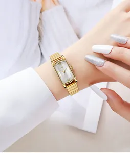 Detail of vintage gold rectangular watch featuring wheat ear bracelet on a female wrist