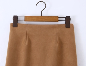 Detail of high-waist brown faux suede skirt featuring a side zipper and soft fabric texture