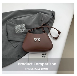 Close-up of brown shoulder bag with silver bow accent and smartphone for size comparison